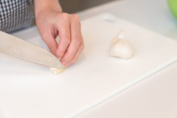 料理をする女性　手元　にんにく