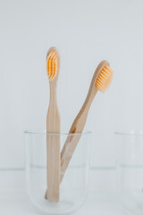  toothbrush in a transparent glass cup on the sink in a bright bathroom.Human hygiene concept 