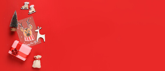 Christmas holiday miniatures with gift and greeting card on red background with space for text