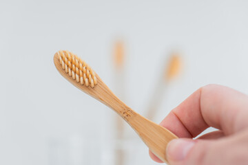 bamboo toothbrush.Teeth cleaning.Toothbrush with toothpaste in hand under tap water in bathroom....