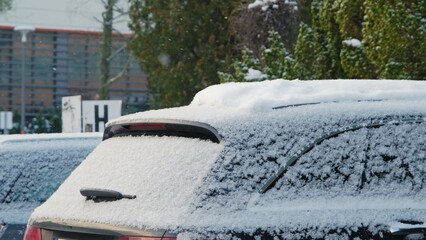 Car on Outdoor Parking Lot Covered in Fresh White Snow Falling on Cold Winter Day