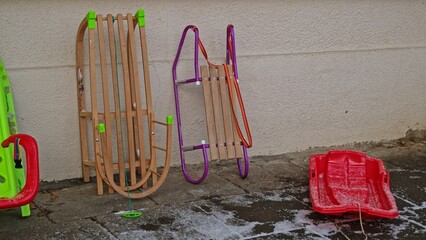 Various Types of Kid Winter Sled Left Outside of School Building