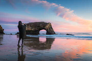 Woman enjoying the sunset in Natural Bridges State Beach of Santa Cruz, CA USA