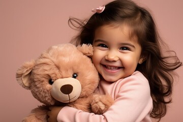 Smiling Little Girl Hugging Teddy Bear on Pink Background