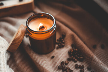 Burning candle and coffee beans, cozy photo