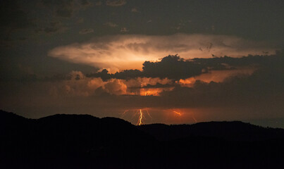Lightning storm with hills in foreground