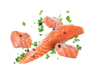 Fresh salmon pieces and spices falling on white background