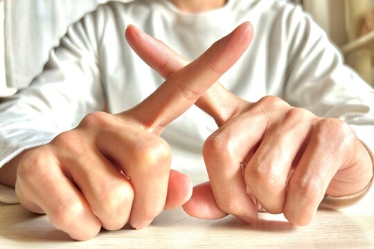 指でバツを作る若い男性・禁止や拒否