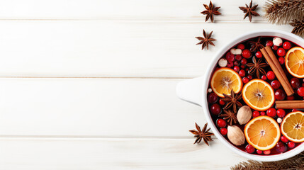 Hot mulled wine with fruits and spices winter cocktail on white wooden table