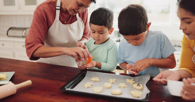 Sprinkles, cookies and children with grandmother and mother in kitchen for sweet treats, dessert or snack. Bonding, child development and boy kids learning to bake biscuits with mom and senior woman.