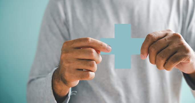Hands hold plus and healthcare medical icon, depicting health insurance concept. Conveys access to welfare health and quality care. Highlights medical technology innovation.
