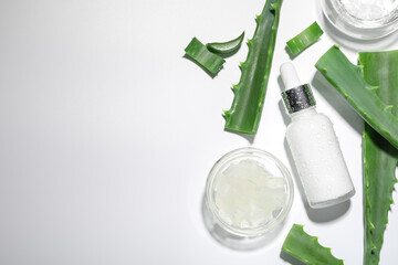 Flat lay composition with cosmetic products and cut aloe vera on white background. Space for text