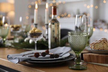 Fototapeta na wymiar Christmas table setting with festive decor and dishware indoors