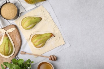 Raw dough with fresh pears, honey and mint on white table, flat lay. Space for text