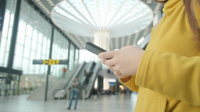 Close up business woman hands using smartphone texting inside airport terminal while waiting for the flight, mobile phone  4K