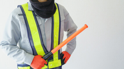ネックウォーマーで防寒対策｜誘導灯を持つ誘導員イメージ