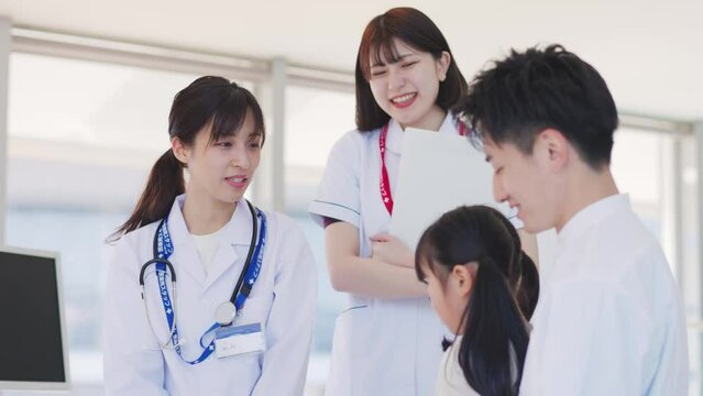 病院の診察室にて子供の診察を行う女性医師	