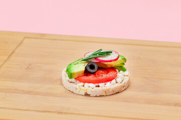 Rice Cake Sandwich with Avocado, Tomato, Cottage Cheese, Olives and Radish on Bamboo Cutting Board....