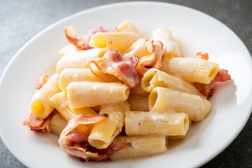 spaghetti rigatoni pasta with white sauce and bacon