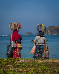 Two women of the Islamic faith. They sell sorongas and souvenirs on the beach. Itinerant trade. Kuta Lombok. Indonesia