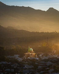 Sunset over the village of Sambaloen. Golden hour. Mosque in the foreground. Around the buildings. Lombok. Indonesia