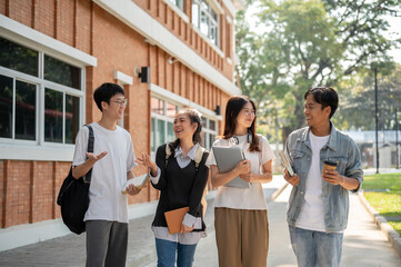 Group of diverse cheerful Asian students friends are enjoying talking while walking in their campus.