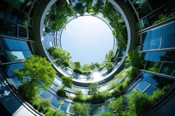Fotobehang Eco-friendly building in the modern city. Sustainable glass office building with tree for reducing carbon dioxide. Office building with green environment. Corporate building reduce CO2. © Artinun