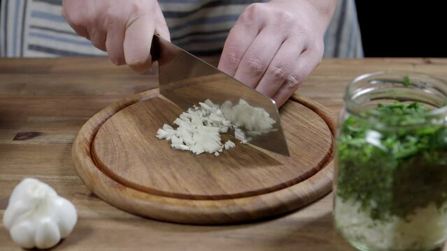 Chef cuts garlic, a fundamental ingredient for meat sauce, chimichurri and cafe de paris butter