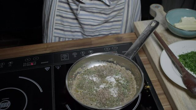 Finishing the seasoning of Cafe Paris butter with aromatic herbs