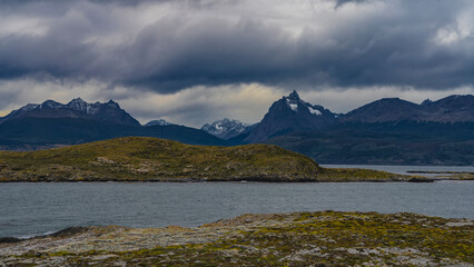 A picturesque mountain range of the Andes against a cloudy sky. The islets in the Beagle Channel...