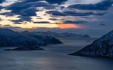 Ośnieżone wybrzeże w Norwegii, skalisty fiord w o zachodzi słońca © Mad Cream
