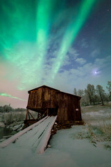 Stary drewniany budynek, na tle zorzy polarnej w Norwegii - obrazy, fototapety, plakaty