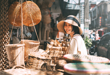 Young adult traveler asian woman travel and shopping at wicker souvenir shop at local street Chiang...