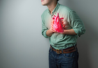 heart disease concept. man pressing on chest with painful expression. severe heartache and having...