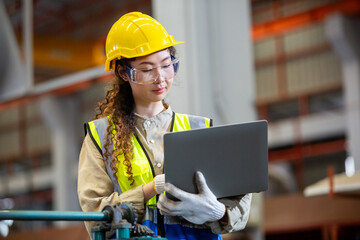 engineer female using laptop working in manufacturing factory. woman worker technician metalwork automated mechanical energy project. - Powered by Adobe