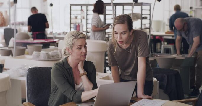 Creative, small business and team talking with laptop, logistics or problem solving on ecommerce website. Startup, collaboration and people with computer in pottery workshop with online inventory