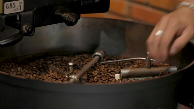 Fresh Roasted Natural Coffee Beans Cascading out of Industrial Coffee Bean Roaster Machine