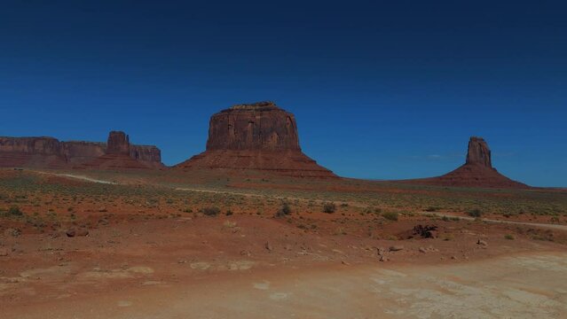 Driving at Monument Valley in Utah and Arizona. Red rock formations in iconic scenic wild west landscape.