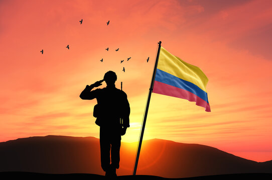 Silhouette of a soldier with the Colombia flag stands against the background of a sunset or sunrise. Concept of national holidays. Commemoration Day.