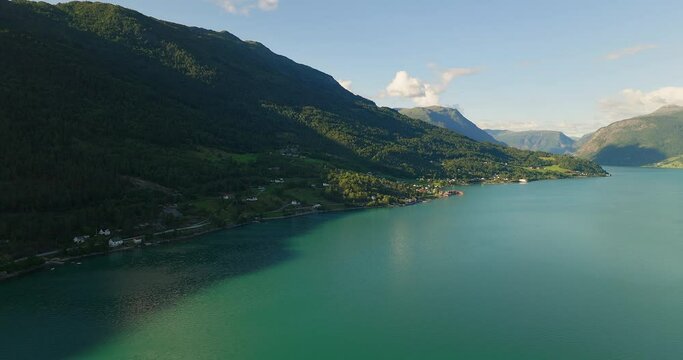 Panoramic aerial view of Lustra Fjorden Norway as shadows from mountain cover hillside and water