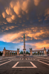 Fototapeta na wymiar Budapest, Hungary - Unique mammatus clouds over Heroes' Square Millennium Monument at Budapest after a heavy thunderstorm on a summer afternoon sunset with warm golden colors