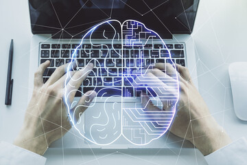 Double exposure of creative artificial Intelligence symbol with hands typing on laptop on background. Neural networks and machine learning concept