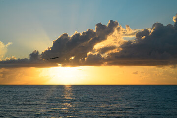 Naklejka premium Sea sunset with cloudy sky and sun through the clouds over. Clouds Ocean and sky background, seascape.
