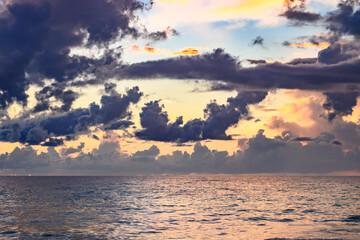 Sunset on tropical beach sea ocean with sunrise clouds. Banner for travel vacation. Scenery sky and reflection rays in water. Dusk, twilight on sea. Pacific ocean.