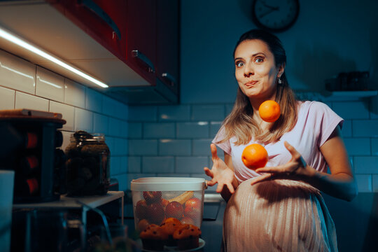 Pregnant Girl Juggling Oranges Craving Some juice. Cheerful mother to be snacking healthy fruits with vitamin C
