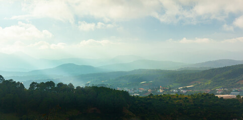 Obraz premium Aerial view of Dalat city in the morning mist with sun light through the blue sky