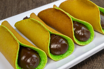 kue manja with chocolate filling served on a white plate 
