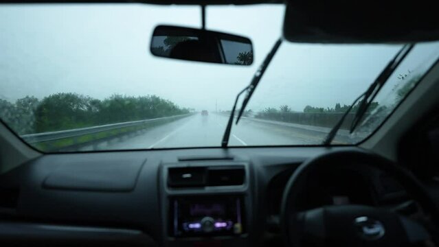 car driving in the rain with wipers on