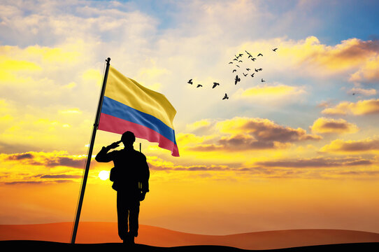 Silhouette of a soldier with the Colombia flag stands against the background of a sunset or sunrise. Concept of national holidays. Commemoration Day.