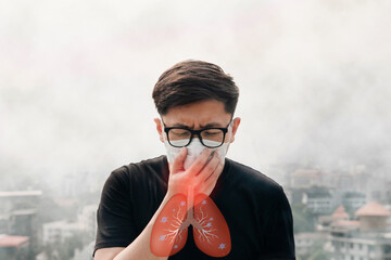 Asian man wear N95 masks to protect against PM 2.5 dust and air pollution over smog city buildings, coughing with sore throat pain, lung cancer, bronchitis,Bronchial. Air pollution pm2.5 concept.